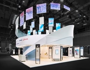 Lufthansa exhibition stand with floating displays and white, wavy elements.