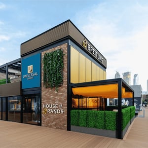 A corner view of the luxurious Breitling exhibition stand, featuring a green terrace and a green wall.