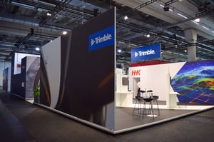 Side view of the Trimble booth showcasing branding and display zones for digital solutions in geodata and surveying.