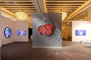 Room with digital artworks, including a large image of a red hand on a black-and-white background.