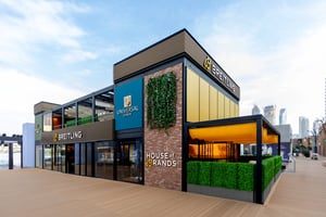 Außenansicht des Breitling‑Pavillons auf der Dubai Watch Week 2025 mit dem House‑of‑Brands‑Bereich, vertikaler Begrünung und einer modernen zweigeschossigen Architektur.