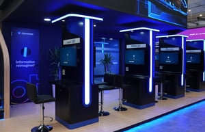 Close-up view of the OpenText booth workstations with futuristic LED lighting and screens for product demonstrations.