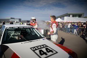 Mitarbeiterevent mit zwei Personen neben Rennwagen Nummer 44