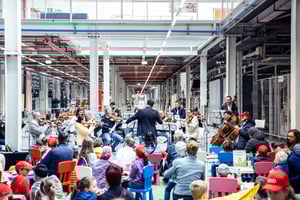 Mitarbeiterevent mit sitzenden Teilnehmern in industrieller Umgebung