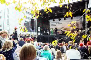 Mitarbeiterevent mit Künstlern auf Bühne und Zuschauern im Freien