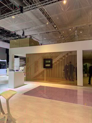 Section of the Brückner Group booth with a wooden slat wall and a large black ‘B’ logo as a focal point.