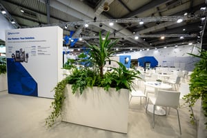 Detailansicht des DN Solutions Messestandes mit Produktinformationen und klar strukturierten Besprechungsbereichen.
