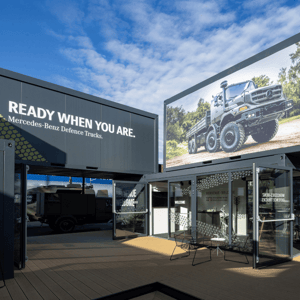 Messestand von Mercedes-Benz Defence Trucks auf einer Militär Messe mit Präsentation von Spezialfahrzeugen für Sicherheits- und Verteidigungsanwendungen.