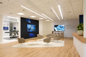 Ein weiterer moderner Empfangsbereich mit Sitzgelegenheiten und einem großen Bildschirm an der Wand.