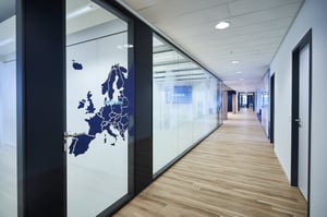 Ein langer Korridor mit einer Glaswand, die eine Karte von Europa zeigt.
