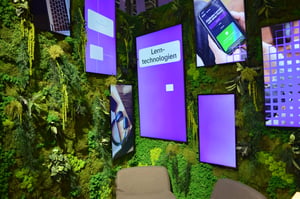 Green walls with monitors of various sizes hanging on them.