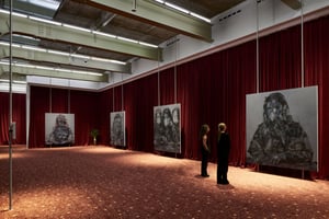 Blick durch die Ausstellung von Avery Singer bei Hauser & Wirth Zürich mit großformatigen, monochromen Gemälden, die frei vor tiefroten Samtvorhängen hängen. Zwei Besuchende betrachten die Kunstwerke in der weitläufigen Galerie.