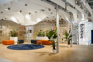 Lounge-Bereich des Krones Messestandes mit Holzlamellen, Pflanzen und modernen Sitzmöbeln für Networking.
