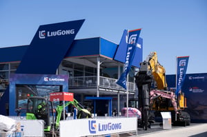 Liuogong Außenmessestand auf der Transportationsmesse bauma mit einem blauen Doppelstockgebäude und großen Exponaten.
