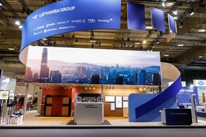 Main view of the Lufthansa Group exhibition booth at ITB 2026 with a circular ceiling structure and a big LED display.
