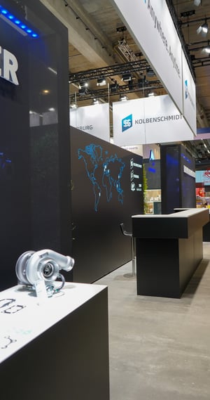 MS Motorservice exhibition stand featuring a graphic world map highlighting the global availability of spare parts.