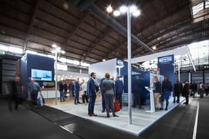 NETSTAL exhibition stand with people visiting the booth.