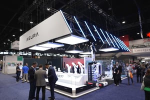 NEURA Exhibition stand with futuristic design elements, robotics machines and surrounding people.