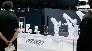 Detailaufnahme von Roboterarmen am Stand von NEURA Robotics, im Vordergrund Omron-Branding sichtbar.