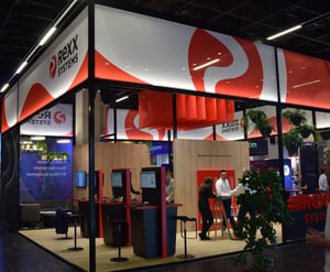 Eckansicht des Rexx Systems Messestandes auf der ZPE Köln 2025 mit einem Pavillon Bausystem, weißen und roten Designelementen sowie Display-Stationen.