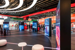 Offener Messebereich des SEW‑Stands mit beleuchteten Display-Säulen, digitalen Grafiken und Besucherverkehr in einer weitläufigen Halle.