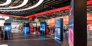 Offener Messebereich des SEW‑Stands mit beleuchteten Display-Säulen, digitalen Grafiken und Besucherverkehr in einer weitläufigen Halle.