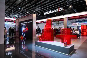 Bereich des SEW EURODRIVE Messestandes mit modularen Antriebssystemen in leuchtendem Rot und Informationswänden zu innovativen Lösungen.