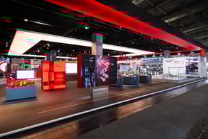 Gesamtansicht des SEW EURODRIVE Messestandes mit markantem roten Rahmen, Produktpräsentationen und interaktiven Informationsbereichen.