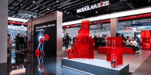Section of the SEW-EURODRIVE booth showcasing modular drive systems in bright red and information panels about innovative solutions.