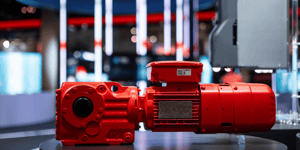  Close-up of a red SEW-EURODRIVE drive module in front of a modern booth design with LED lighting. 