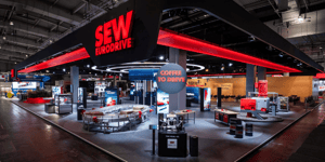 SEW-EURODRIVE booth at HANNOVER MESSE 2025 featuring a striking red frame and display areas for drive technology and automation solutions.