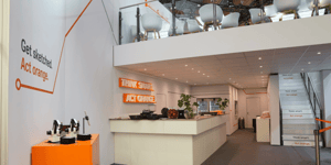 Interior view of the STILL booth with a reception area and clear brand message ‘Get started. Act orange’.