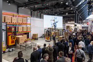 Live-Demonstrationsbereich des STILL-Messestandes mit Gabelstaplern und Regalsystemen, umgeben von zahlreichen Besuchern.