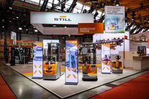 Frontansicht des STILL-Messestandes mit ausgestellten Lagertechnikgeräten und auffälliger Markenpräsentation.