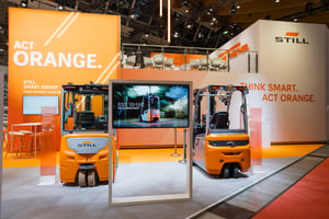 Der STill Messestand auf der von ET GLOBAL organisierten Messe LogiMAT 2026 mit zwei Gabelstaplern im Vordergrund und bedruckten Messestandwänden im Hintergrund.