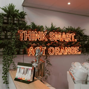 A lounge and hospitality area featuring a green accent wall, illuminated lettering and high-quality visitor hospitality at the STILL exhibition stand during LogiMAT.