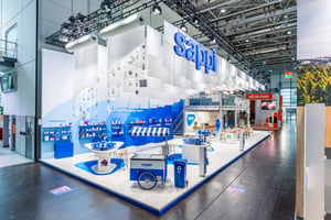 Sappis Messestand auf der Interpack 2026 mit von der Decke hängenden Papierrollen als Hauptdesignelement.