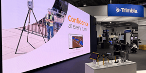 Trimble booth at Intergeo 2025 in Frankfurt featuring a large LED display, surveying technology presentations, and a central information desk.