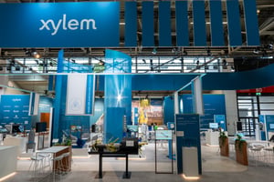 Front picture of Xylem's exhibition booth with a blue ceiling structure and textiles hanging from the ceiling.