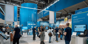 View of the exhibition stand with numerous visitors looking at the information boards.