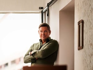 The CEO of ET GLOBAL, Dr Magnus Ekerot, is standing with his arms crossed in front of a bright window.