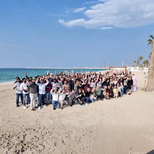 The ELECTRA team posing together on a beach.