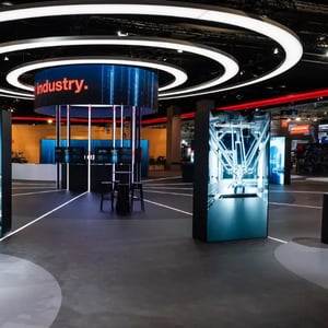 Award-winning exhibition booth for SEW-EURODRIVE with circular lighting elements and modern design elements.
