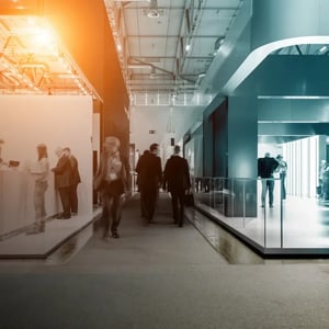 Black and white photography of two busy exhibition booths, representing EXCITE's and ET GLOBAL's common interest: exhibitions stands.