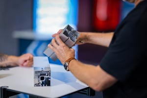 A person is holding an Octanorm system component.
