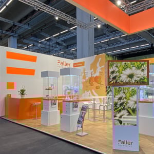 Sustainable exhibition stand with orange design elements and depictions of daisies.