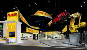 Highlight shot of the FANUC exhibition booth with yellow design and a flying car