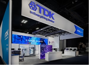 Frontansicht des TDK Messestands auf der CES 2026 mit großem LED‑Header, beleuchtetem Logo und offenen Präsentationsbereichen.