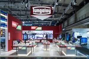 Section of the IMC Group booth with Tungaloy branding, red walls, and exhibits for cutting tools and manufacturing solutions.